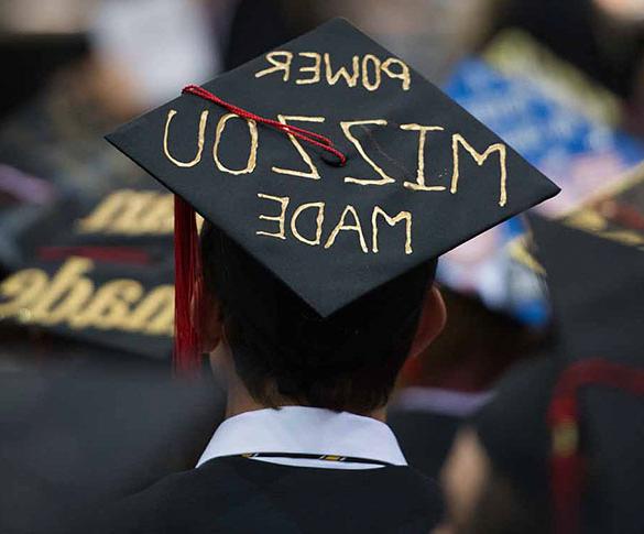 Student wearing mortarboard with "Power 世界杯在哪里买球 Made" painted on it