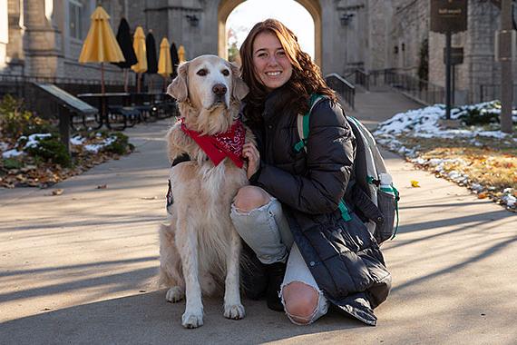 Student poses with service dog in front of Memorial Union
